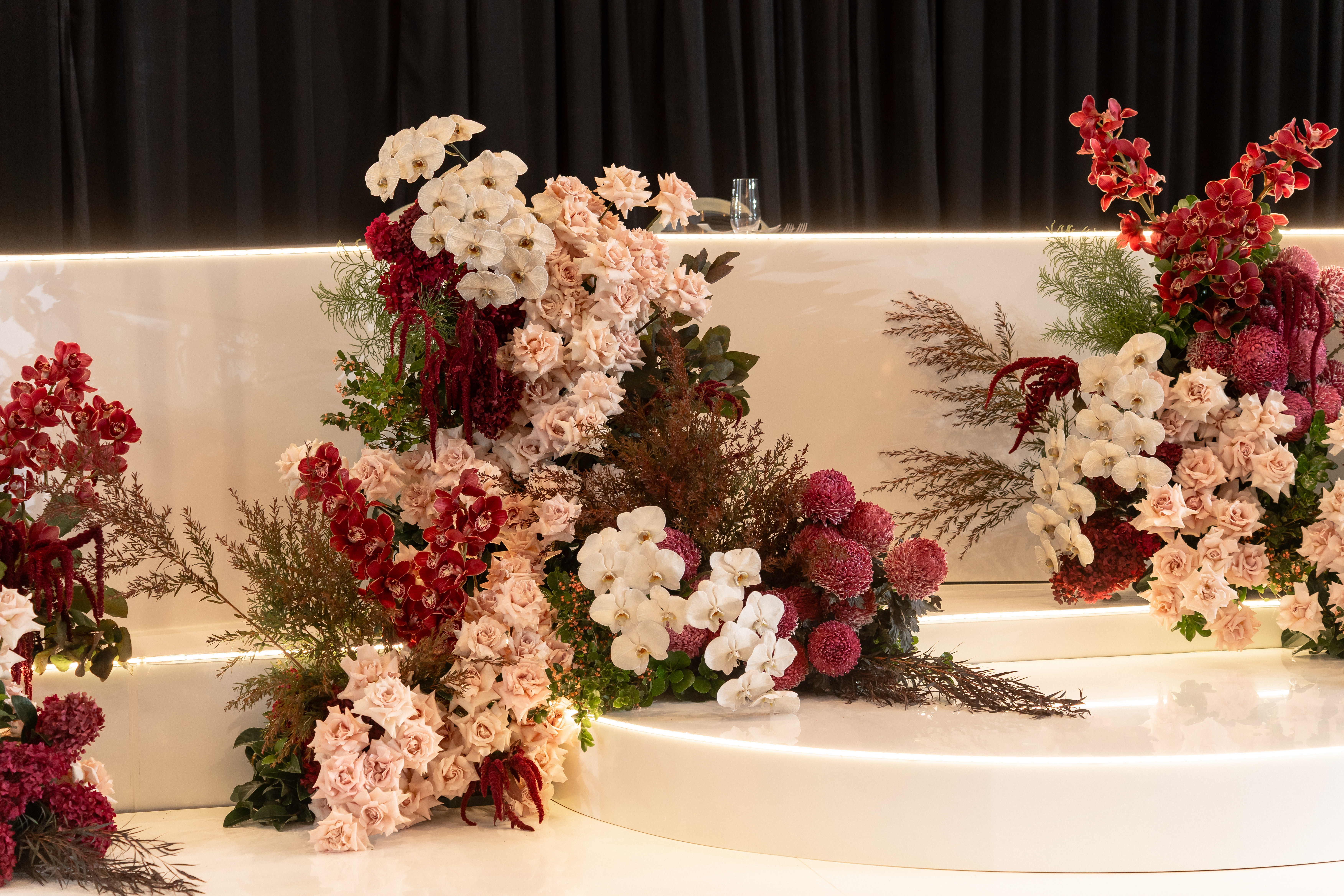 Close-up of luxury floral centrepiece with orchids, roses and pampas grass